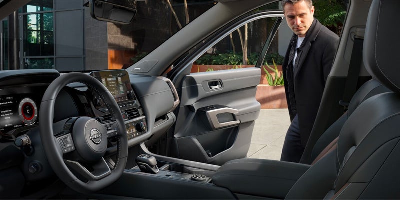 Man looking at the passenger side interior of the Nissan Pathfinder