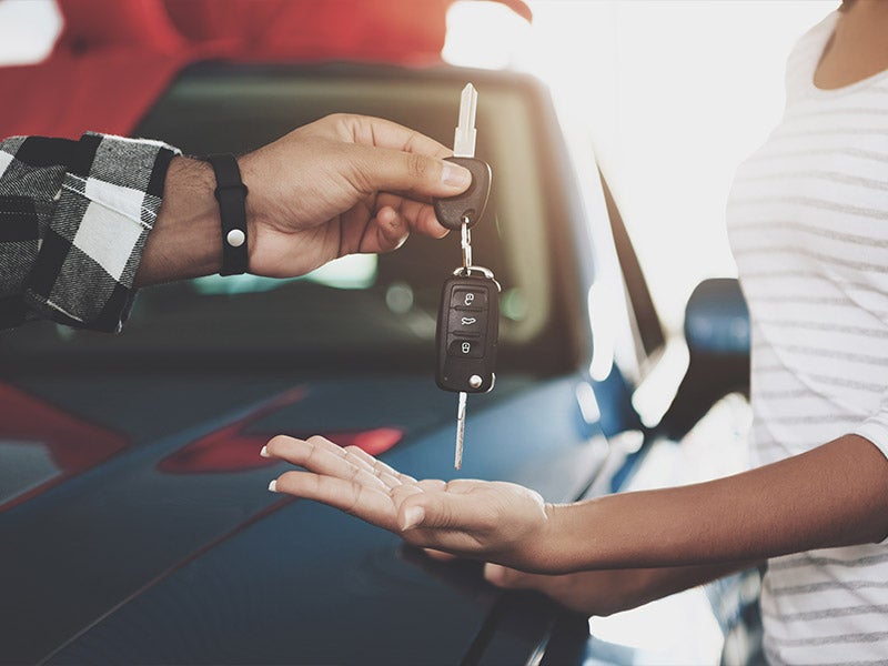 Man handing a woman a pair of keys at Nissan of Macomb in Clinton Township MI