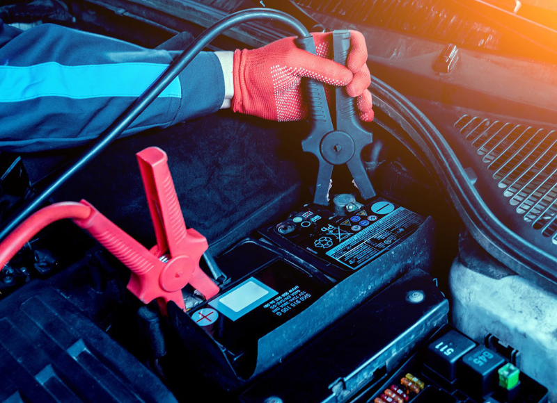 Car battery being charged with jumper cables